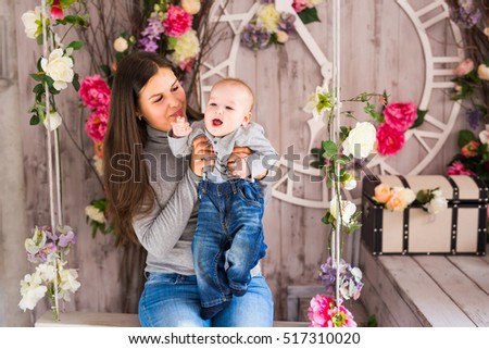 Loving mother playing with her baby in the room