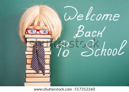 Woman teacher in front of blackboard with title WELCOME BACK TO SCHOOL