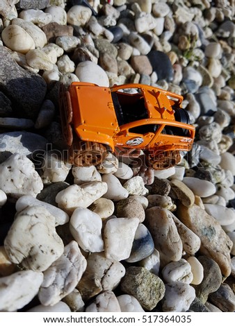 Orange kids car on the rocks