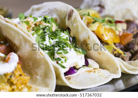 Close up on fresh tacos on serving plate eye level shot