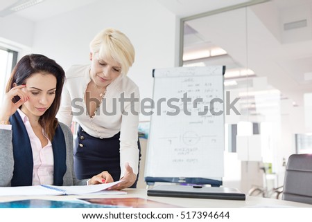 Businesswomen reviewing project at desk in office