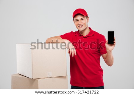 Delivery man with phone near the box. isolated gray background