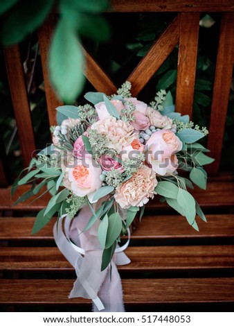 beautiful and gentle wedding bouquet lying on a wooden chair