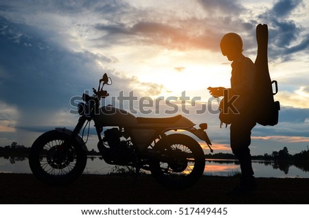 A man riding motorcycle,Silhouettes picture ,play guitar