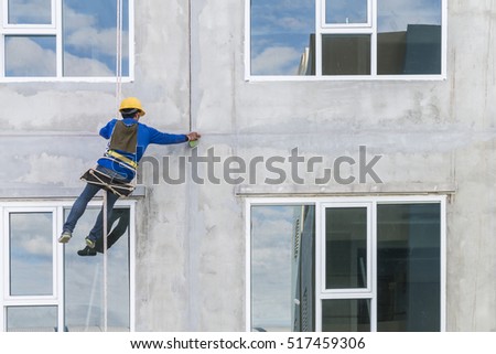 The worker man abseiling with rope on construction site