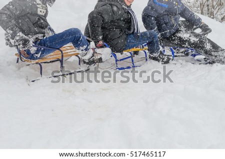Snow, winter and wooden sledges. Three children sledding, clung to each other