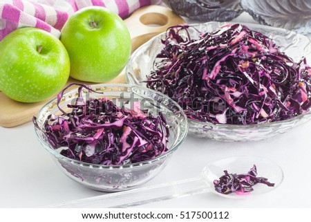 Vegetarian salad of red cabbage with grated green apple, oil and vinegar in a glass bowl