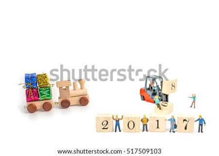 miniature worker team building standing front of forklift machine with 2017 number on wooden block on white background, decoration to Happy new year 2017 concept.