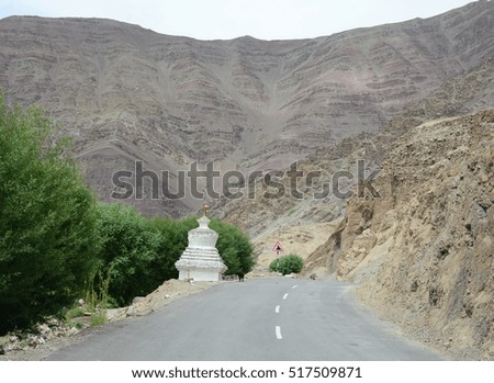 Road with white stupa on high altitude Ladakh-Leh road in Himalayan mountain, state of Jammu and Kashmir, India.