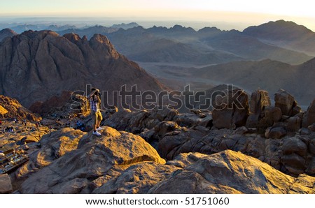 A man taking pictures of mountains in the sun
