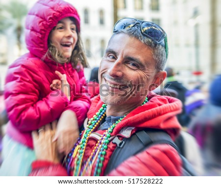 Father and daughter having fun in New Orleans street on Mardi Gras.