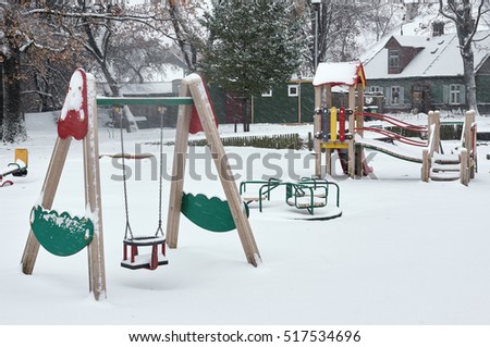 children playground in winter after in snowfall