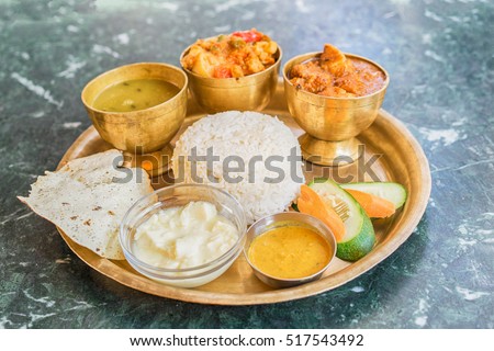 Traditional Nepalese food - thali (dal bhat) in a restaurant. Selective focus.  Royalty-Free Stock Photo #517543492