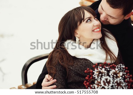 beautiful and young couple sitting on bench together