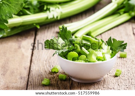 Fresh sliced celery in a white bowl on a vintage wooden background, selective focus Royalty-Free Stock Photo #517559986