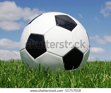 Football in the grass against blue sky