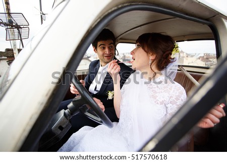 Bride and groom inside a classic car.