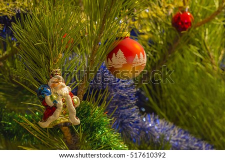 beautiful small santa clause,red christmas balls and garland on christmas tree .