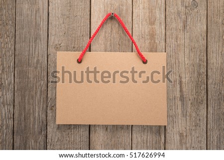 Signboard with rope on wooden background 
