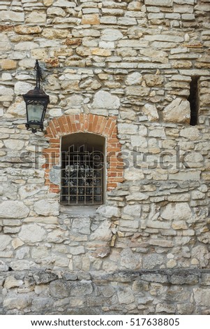 Lantern and window with lattice on the stone wall of the castle. Olesko castle