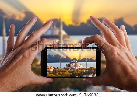 Travel concept. Hands making photo of night city with smartphone camera. Istanbul at sunset. Turkey.