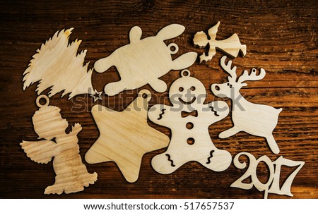 Handmade Christmas decorations laying in a group - wooden rabbit, angel with star, christmas tree, deer, 2017 happy new year on wooden table background