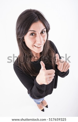 Full length of cheerful pretty young woman standing with ok sign
