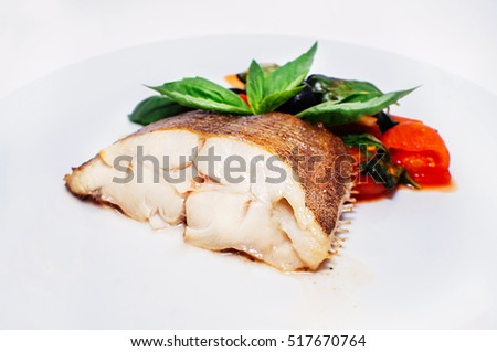 white boiled fish halibut with vegetables on a plate isolated