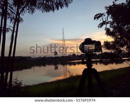 Outdoor photography concept. DSLR camera against a beautiful sunset.