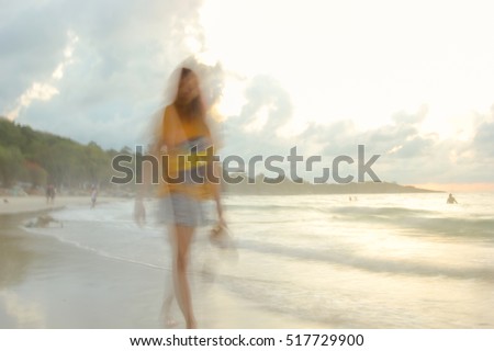 A woman walking on the beach at dawn. slow speed shutter
 
