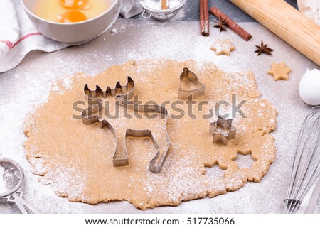 Preparing Christmas gingerbread cookies with cutter, dough and rolling pin - homemade festive Christmas bakery. Ingredients and utensils for bakery.