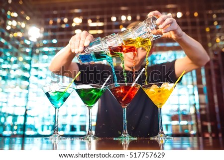 Barman show. Bartender pours alcoholic cocktails. Royalty-Free Stock Photo #517757629