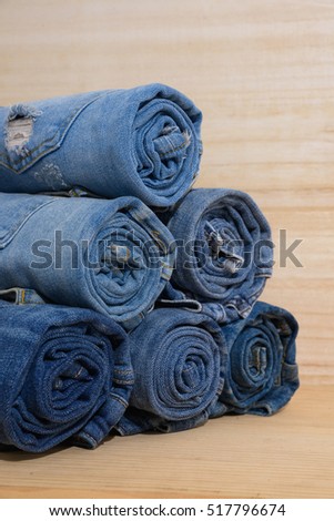 stack of rolls of jeans-wooden board background