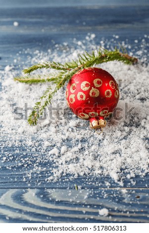Red Christmas decorations on spruce branches with snow