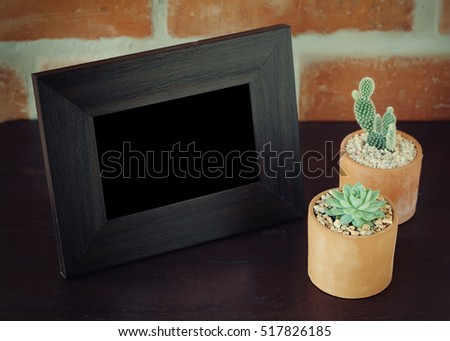 photo frame with Miniature succulent plants on the wooden table - Vintage Filter.