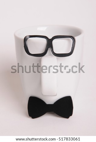 White coffee cup like a man on white background. Hipster style, bow tie, glasses