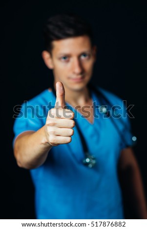 friendly male doctor in studio, thumbs up, showing failed, good news, health-care