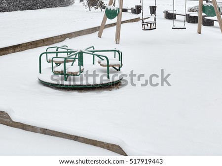 children playground in winter after in snowfall.