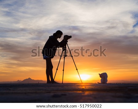 Female photographer capturing a beautiful sunset,cat