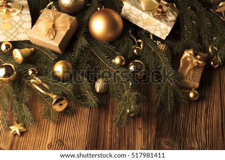 Christmas decoration. Christmas presents in boxes on a wooden background with copy space. Golden baubles. Christmas theme. Presents on a wooden table. Golden and brownish aesthetics.