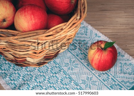 Basket with apples and napkin on wooden table