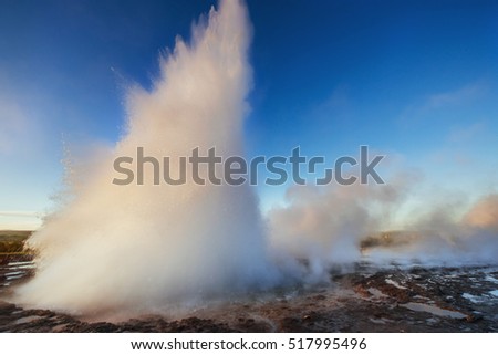 Strokkur geyser eruption in Iceland. Fantastic colors. Beautiful pink clouds in a blue sky.