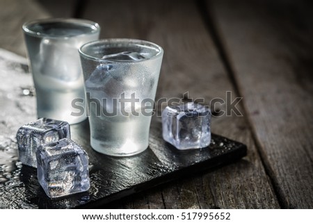 Vodka in shot glasses on rustic wood background Royalty-Free Stock Photo #517995652