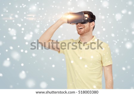 technology, augmented reality, winter, christmas and people concept - happy young man with virtual headset or 3d glasses over gray background and snow