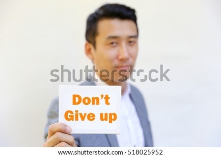 Asian Man with suit hold white card with word "Don't give up"