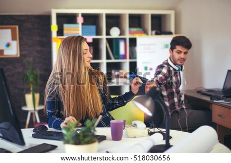 Couple of web designers working together at modern office, using credit card