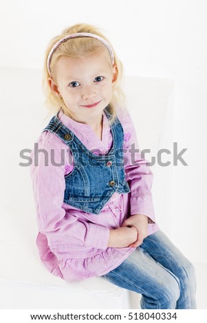 portrait of sitting little girl wearing jeans