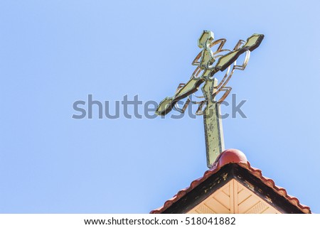 old wooden cross on the roof against blue sky background with copy space
