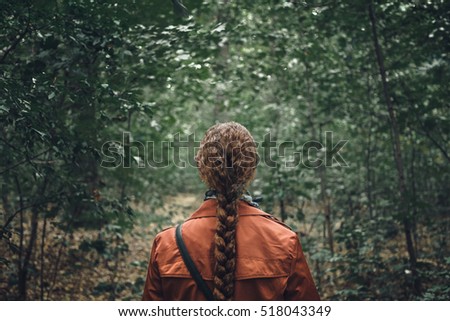 Young Woman with long hair Walking in Forest. Back View, dramatic image concepte