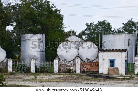Almost abandoned old gas station for agricultural machinery. Barrels of combustible fuel.